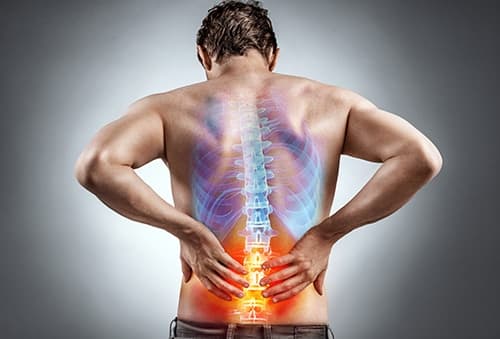 Chiropractor assessing sciatica pain in a patient's lower back and hip in Fernley, NV